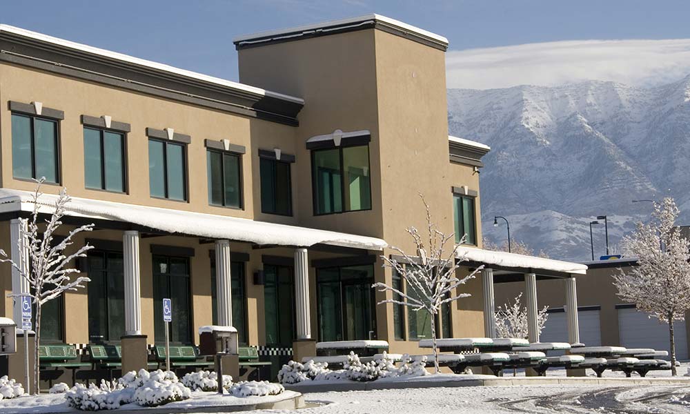 Snow covered business building near mountains in the background