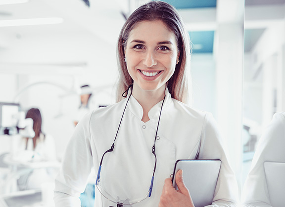 Doctor smiling holding clipboard