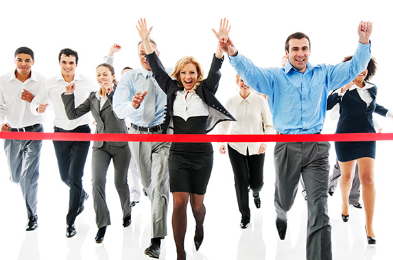 A group of businessmen and women running to the finish line