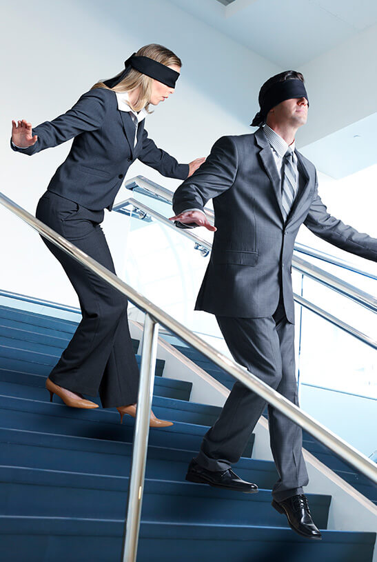 pair of business people walking down stairs blindfolded