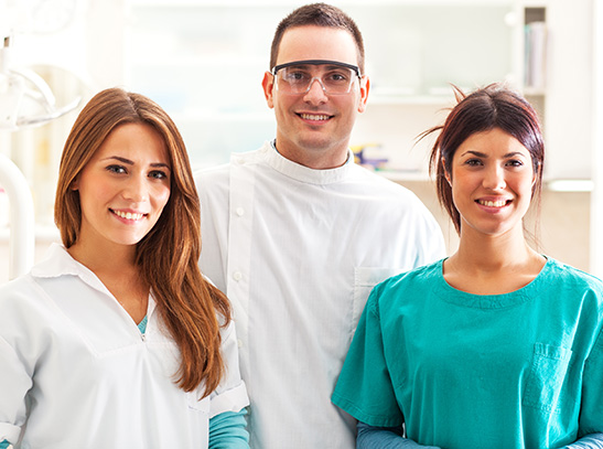 Doctor and hygienists smiling