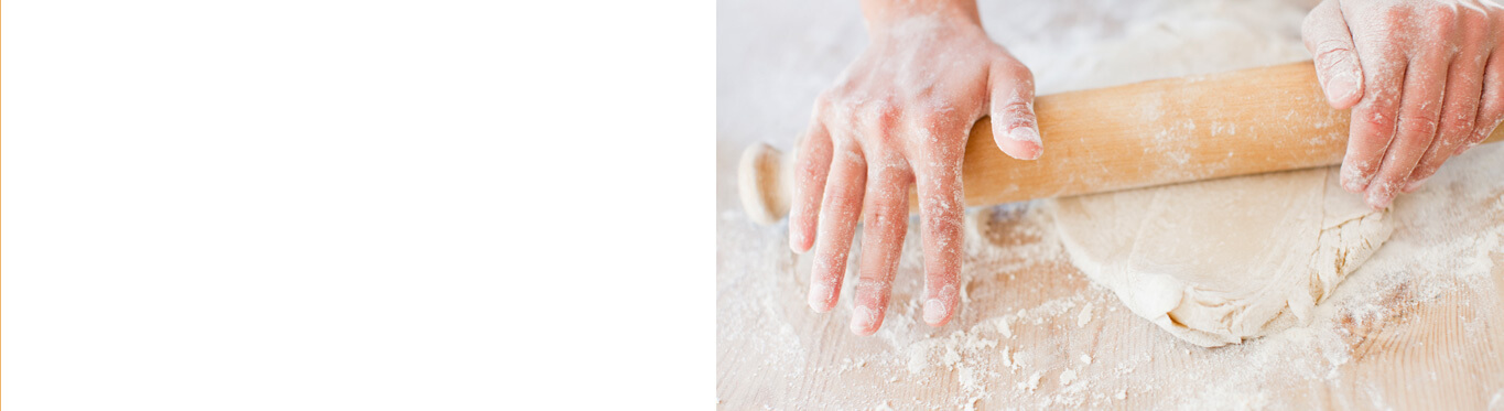 Hands rolling bread dough