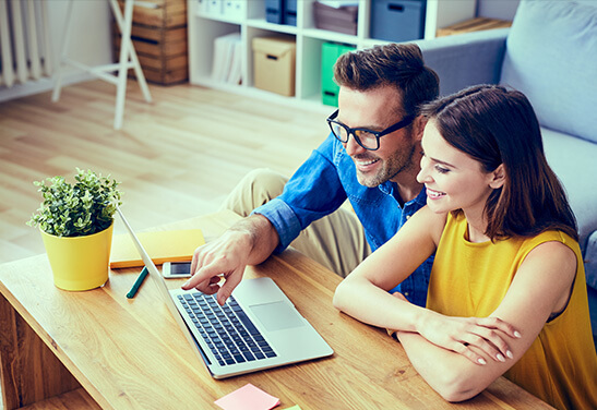 Couple pointing at computer