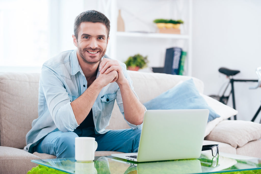 Man sitting next to laptop