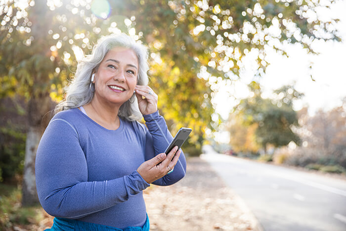 woman putting in earbuds before going out for a walk