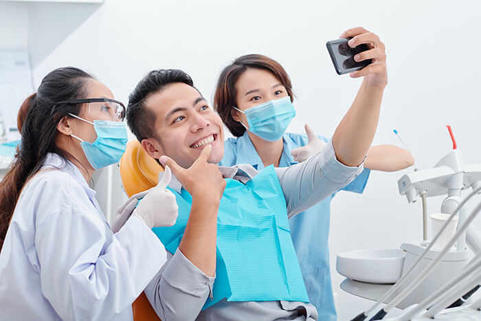 patient posing for a picture with dental staff members